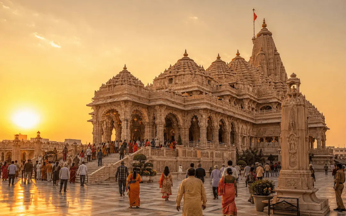 Ram Mandir temple in Ayodhya with intricate sandstone carvings and devotees during sunset.