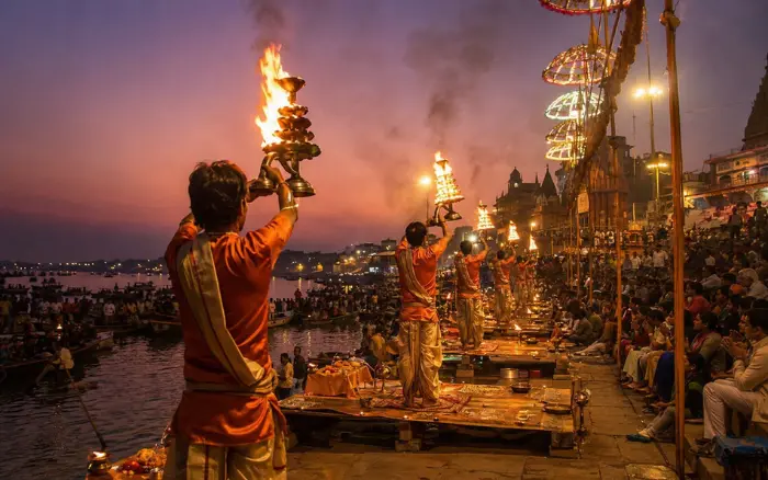 Varanasi Ganga Aarti at Dashashwamedh Ghat with priests performing evening rituals using large brass lamps beside the Ganges River.