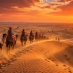 Camel caravan crossing the golden sand dunes during a Rajasthan Desert Safari Experience at sunset